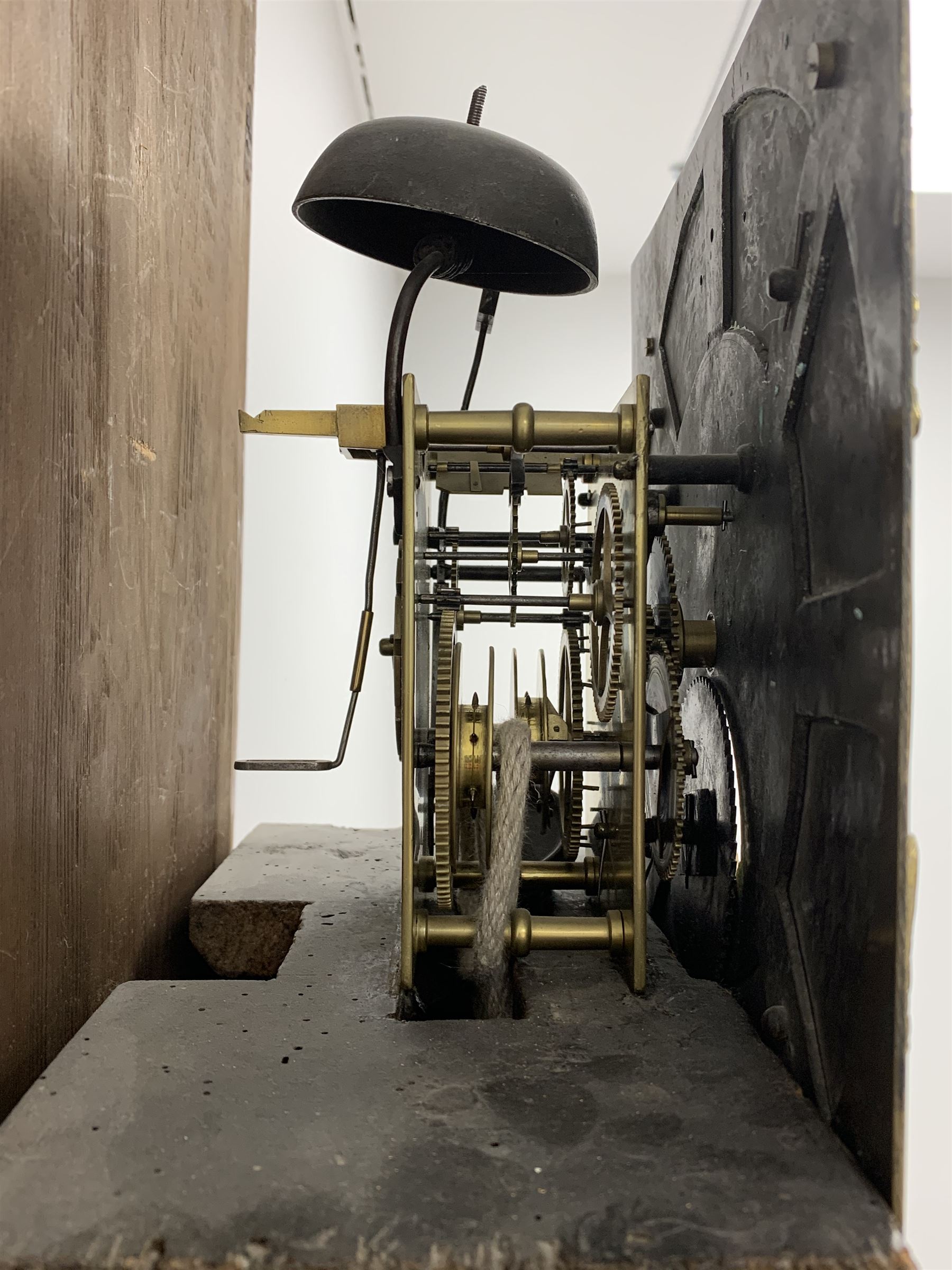 Early 19th century oak longcase clock, projecting cornice over frieze painted with scrolls, square glazed door enclosed by plain pilasters, square brass dial with ornate cast metal spandrels, Roman chapter ring and false subsidiary date aperture, engraved decoration and inscribed 'Torkington, Newcastle', 30-hour movement striking on bell