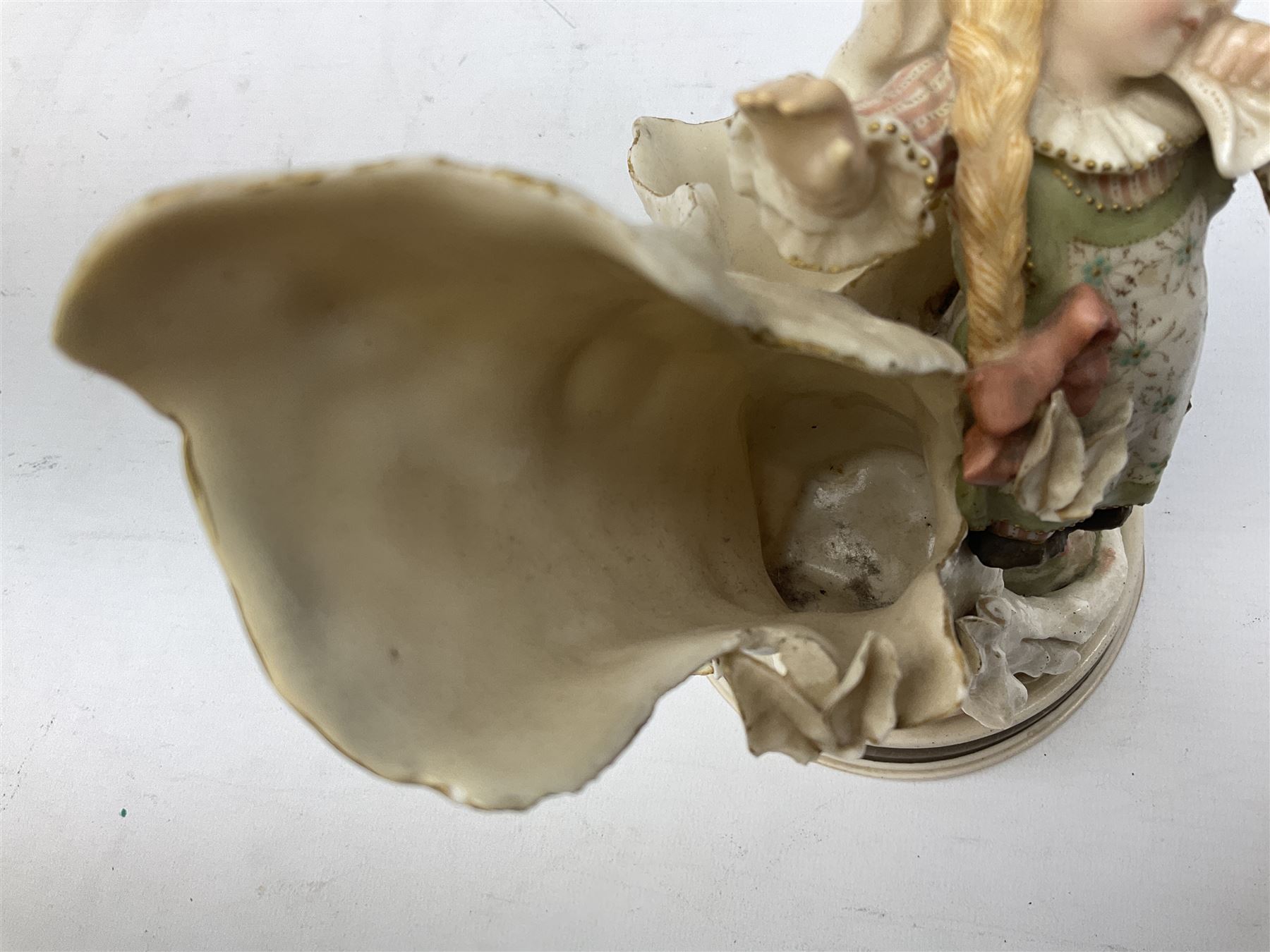 Late 19th century continental spill vase as a young girl standing beside an open tree trunk H21cm; and three German bisque figures (4)