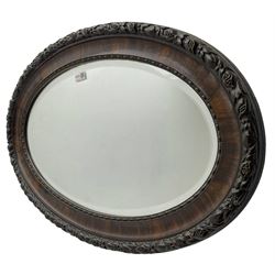 Early 20th century oval mirror, moulded frame decorated with trailing foliage and berries, bevelled plate
