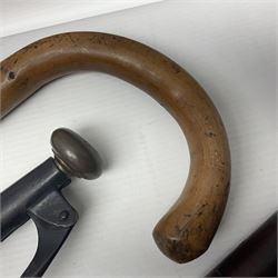 Two late 19th century fruit picker canes, the first example a French ebonised bamboo cane, with pair of fruit scissors to base, the handle stamped Cueille Fruit, the second example with grabbing action, the cap stamped A C Harris, Leicester, together with two other 19th century canes, one with fork and the other with hoe