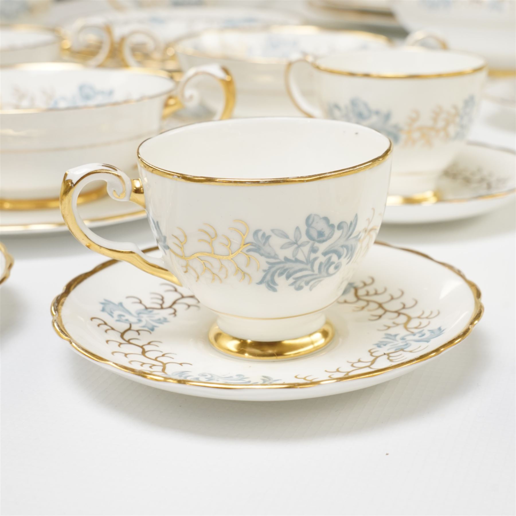 Tuscan Avondale dinner and coffee service for twelve covers with a blue and gilt border pattern comprising  twelve dinner plates, twelve dessert plates, twelve side plates, twelve two handled soup bowls and stands, four vegetable dishes and covers,  four graduated meat plates, sauce boat and stand, twelve coffee cups and saucers and twelve tea plates (106)