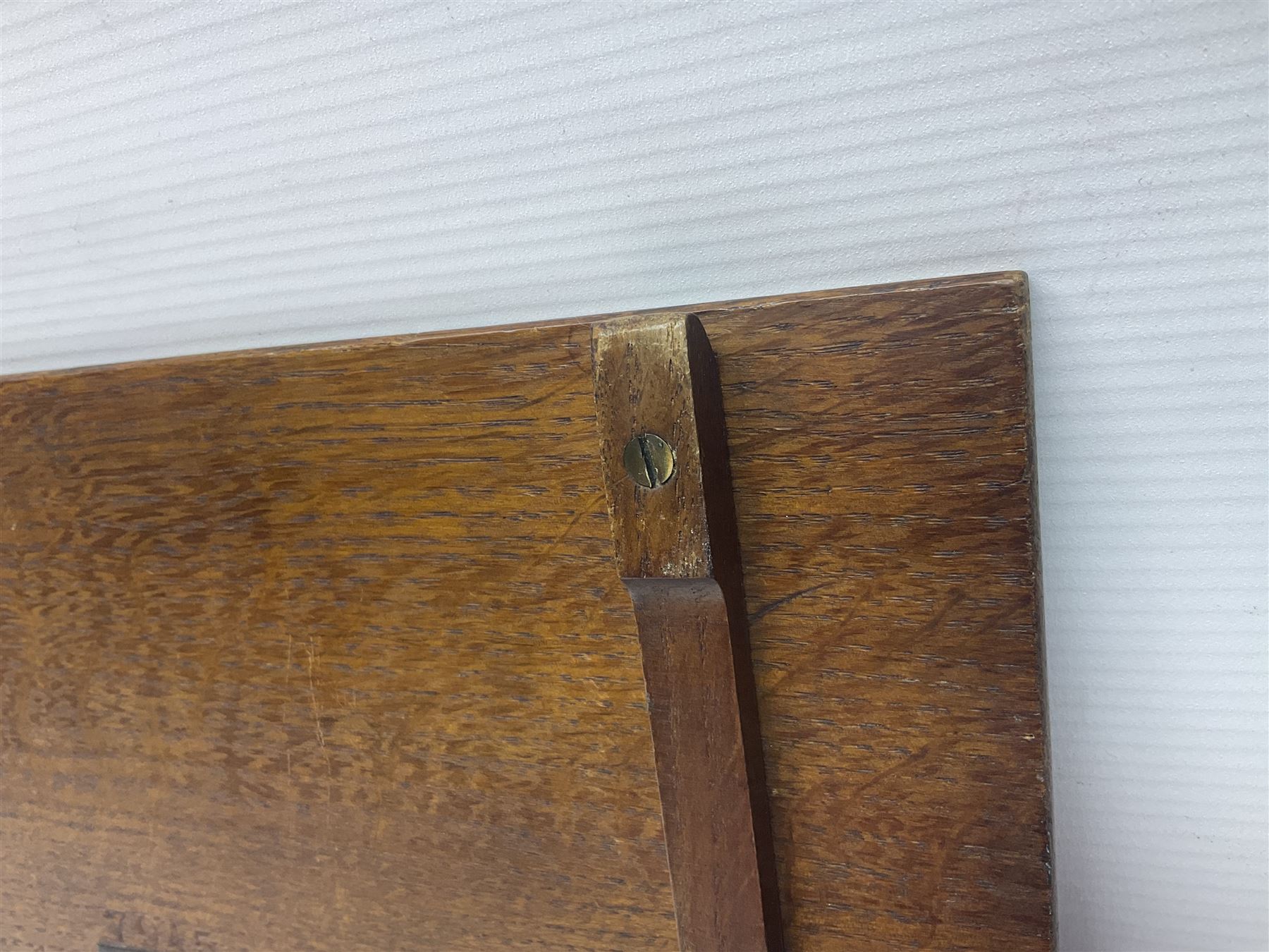 Arts and Crafts oak stand by Arthur Simpson of Kendal, of rectangular form with central hammered pewter panel, surrounded by a border with carved foliate corners, upon two bar supports, bearing label detailed 