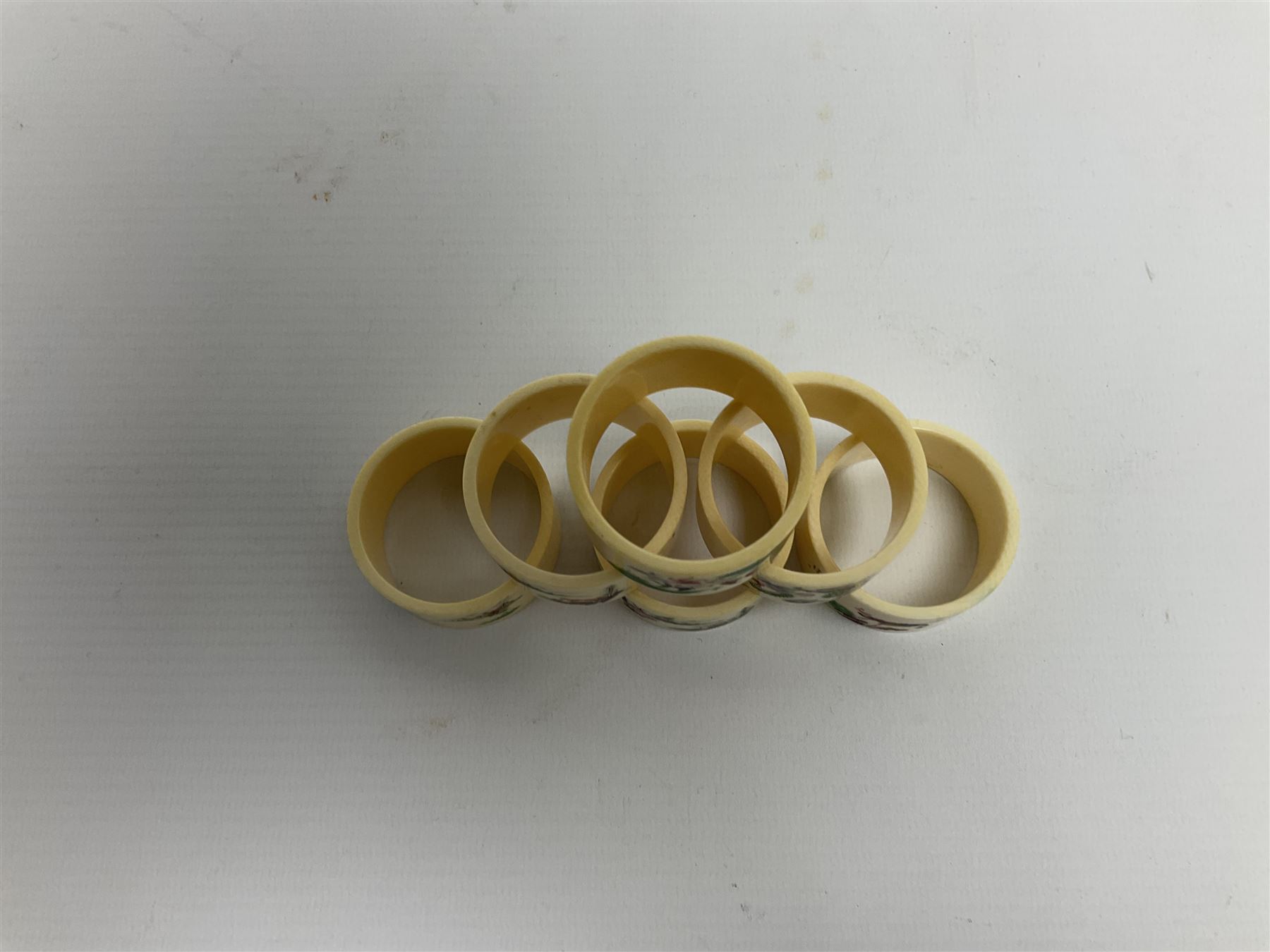 Set of six early 20th century Chinese ivory napkin rings decorated with figural scenes and calligraphy