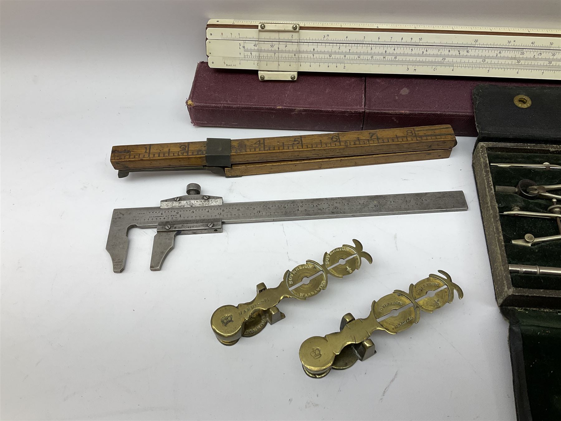 Two Victorian brass sovereign scales, one marked 'Harrison' L10cm; cased set of drawing instruments by G. Thornton Limited Manchester; Chesterman No.770/1 steel vernier caliper; two boxwood rulers; cased slide rule; brass and boxwood rope/wire gauge etc