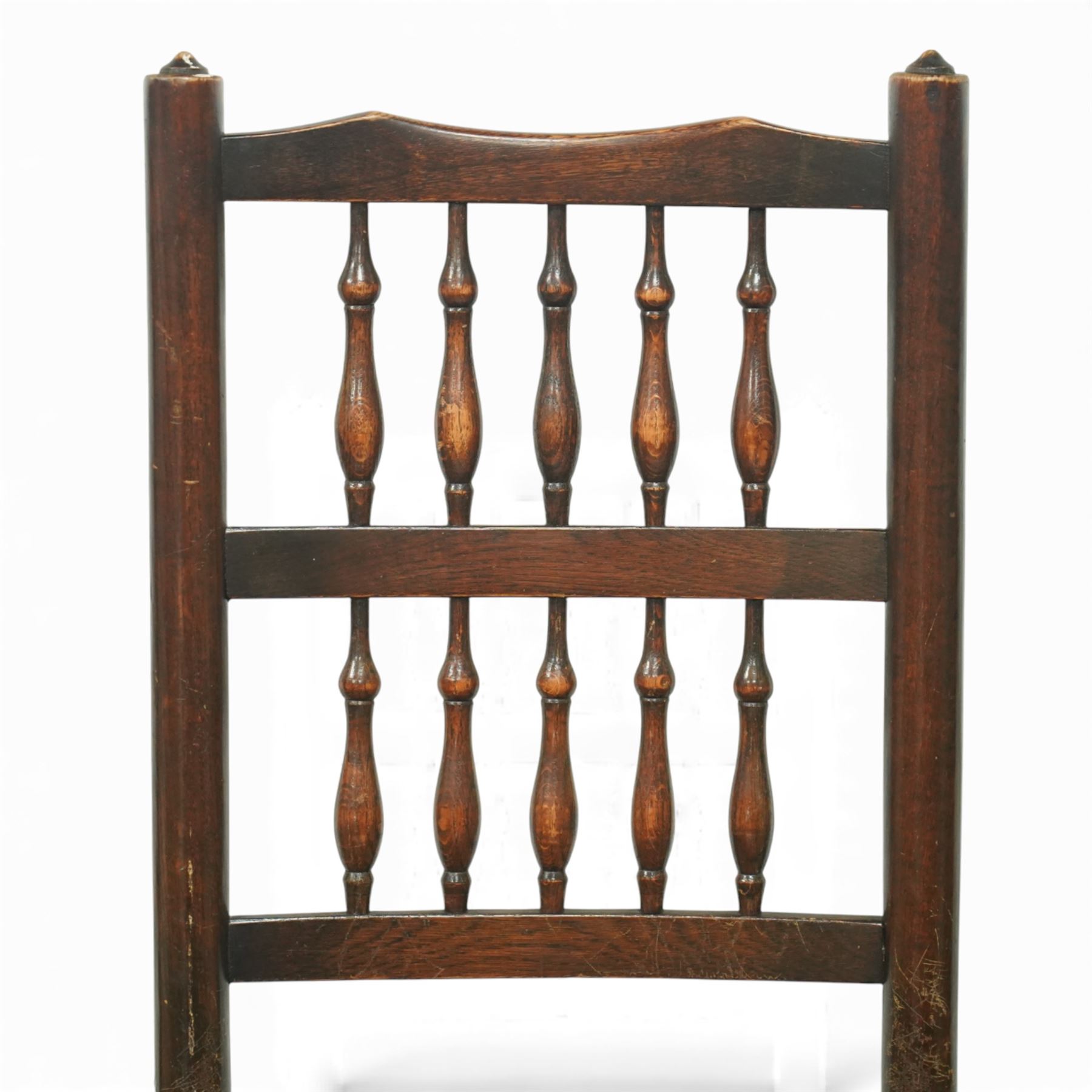 20th century set of five spindle-back dining chairs, with shaped top rails above turned spindle splats, rush seats, turned forelegs united by stretchers