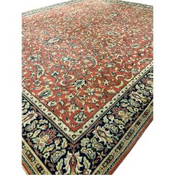 Large Persian design red ground rug, the field decorated with interlacing branches and stylised plant motifs, repeating border with further plant and floral motifs