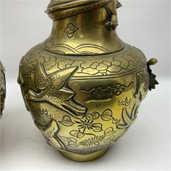 Pair of Chinese brass vases, of ovoid form with elongated neck and fluted rim, decorated in high relief with a dragon chasing a flaming pearl around the neck, the body with dragons, birds and buildings, with character marks beneath, H25cm