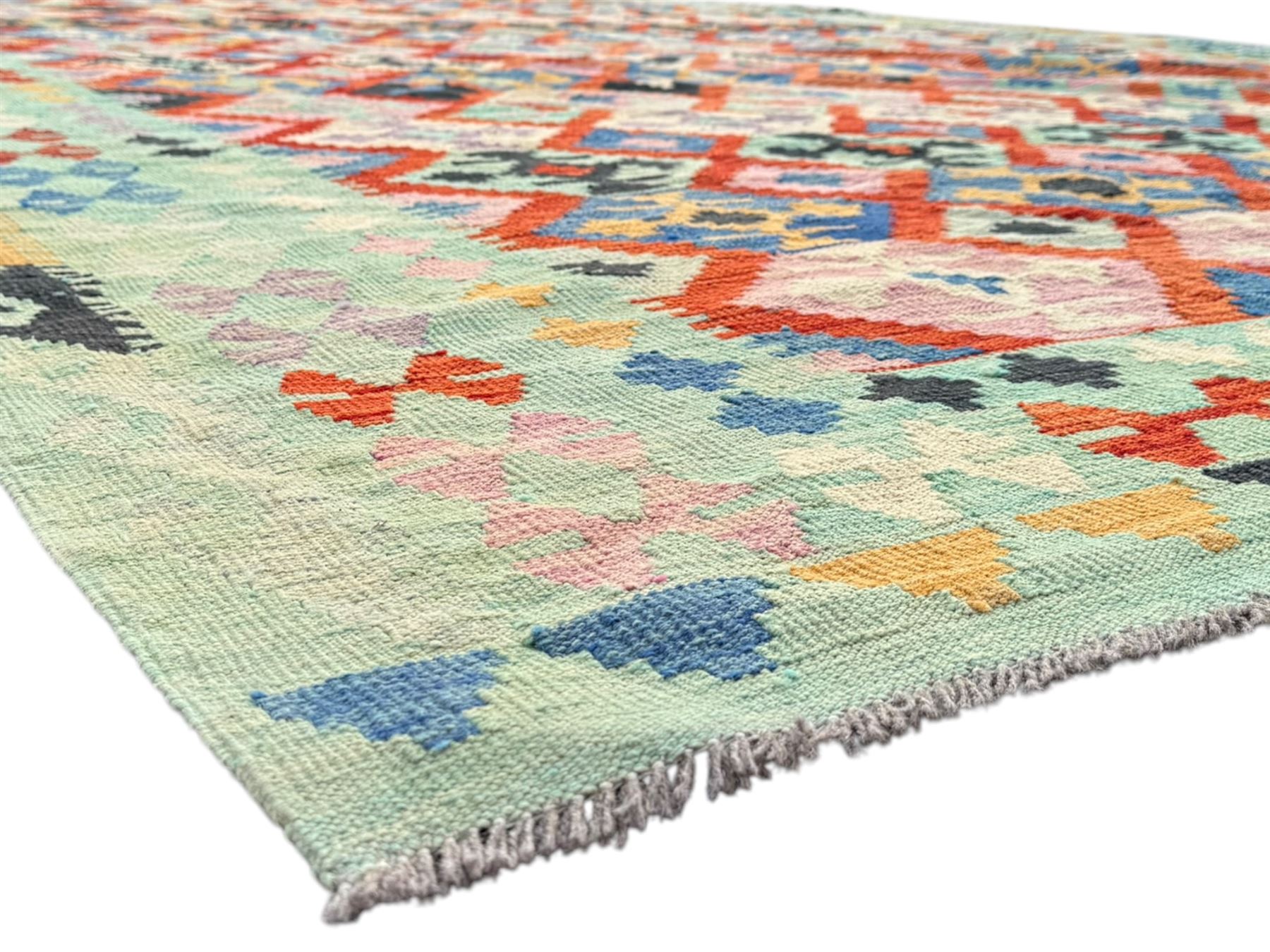 Kilim pastel ground rug, the field decorated with repeating multicoloured geometric diamond motifs, enclosed within matching geometric borders