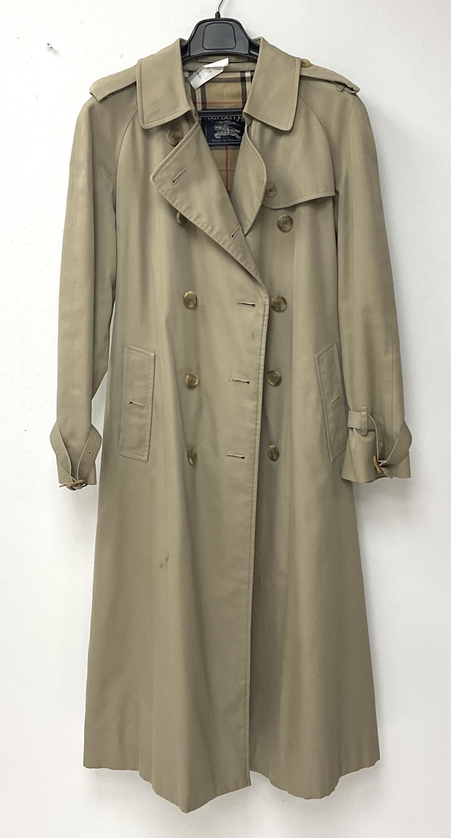 A ladies Burberry trench coat, with waist belt and check lining, no size label, measures approximately arm pit to arm pit L51cm, H117cm