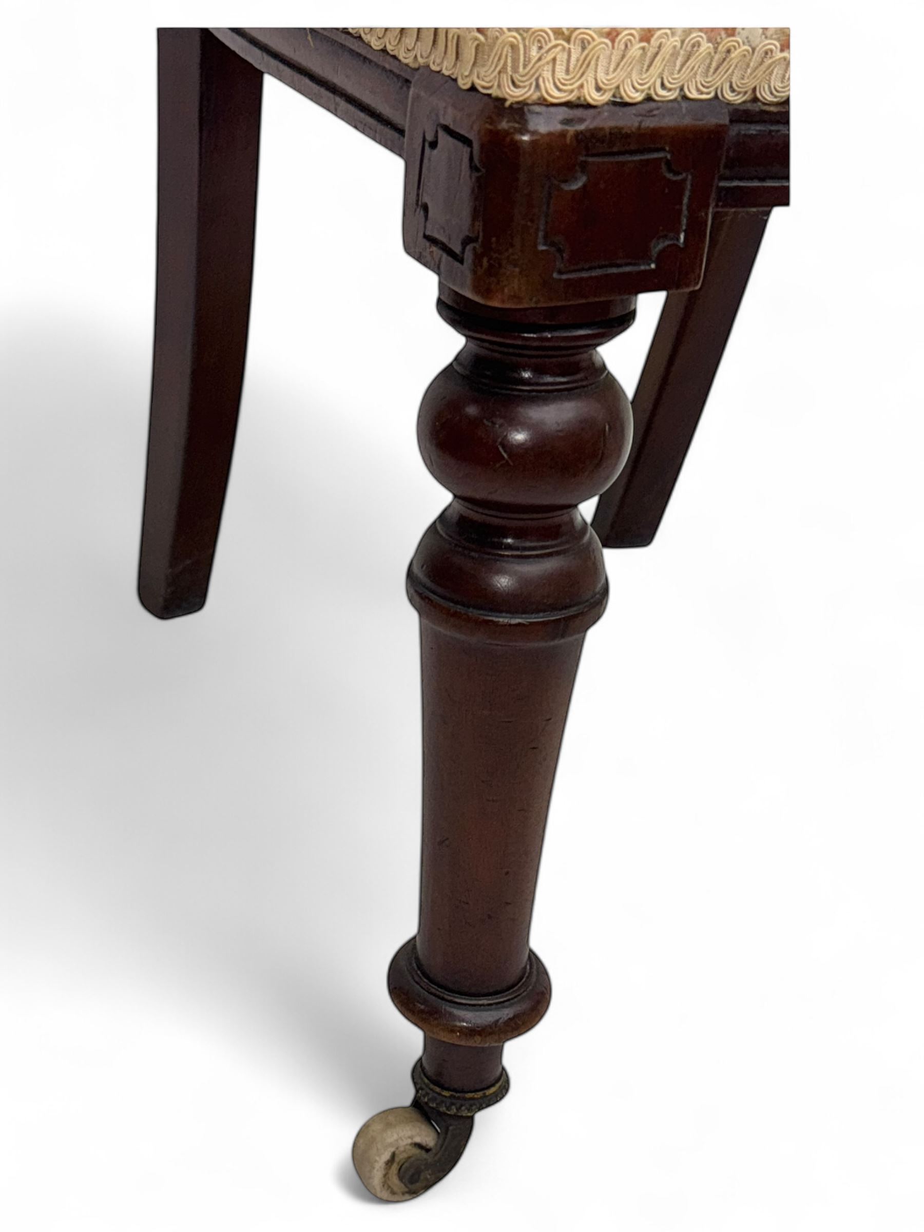 Victorian mahogany centre table, circular top above turned pedestal, terminating on three cabriole legs with scroll feet on porcelain castors, and six scroll carved upholstered dining chairs, with cushion and spindle turned backs, centre table  118x74cm, dining chairs 89x46x50cm