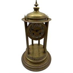 A French gilt brass Rotunda mantle clock with an eight-day enclosed countwheel striking movement striking the hours and half hours on a bell, with six reeded pillars on a circular stepped brass base with a domed canopy and finial, dial with painted Arabic numerals, decorative embossed centre and steel spade hands, under a glass dome. No pendulum or key. 

