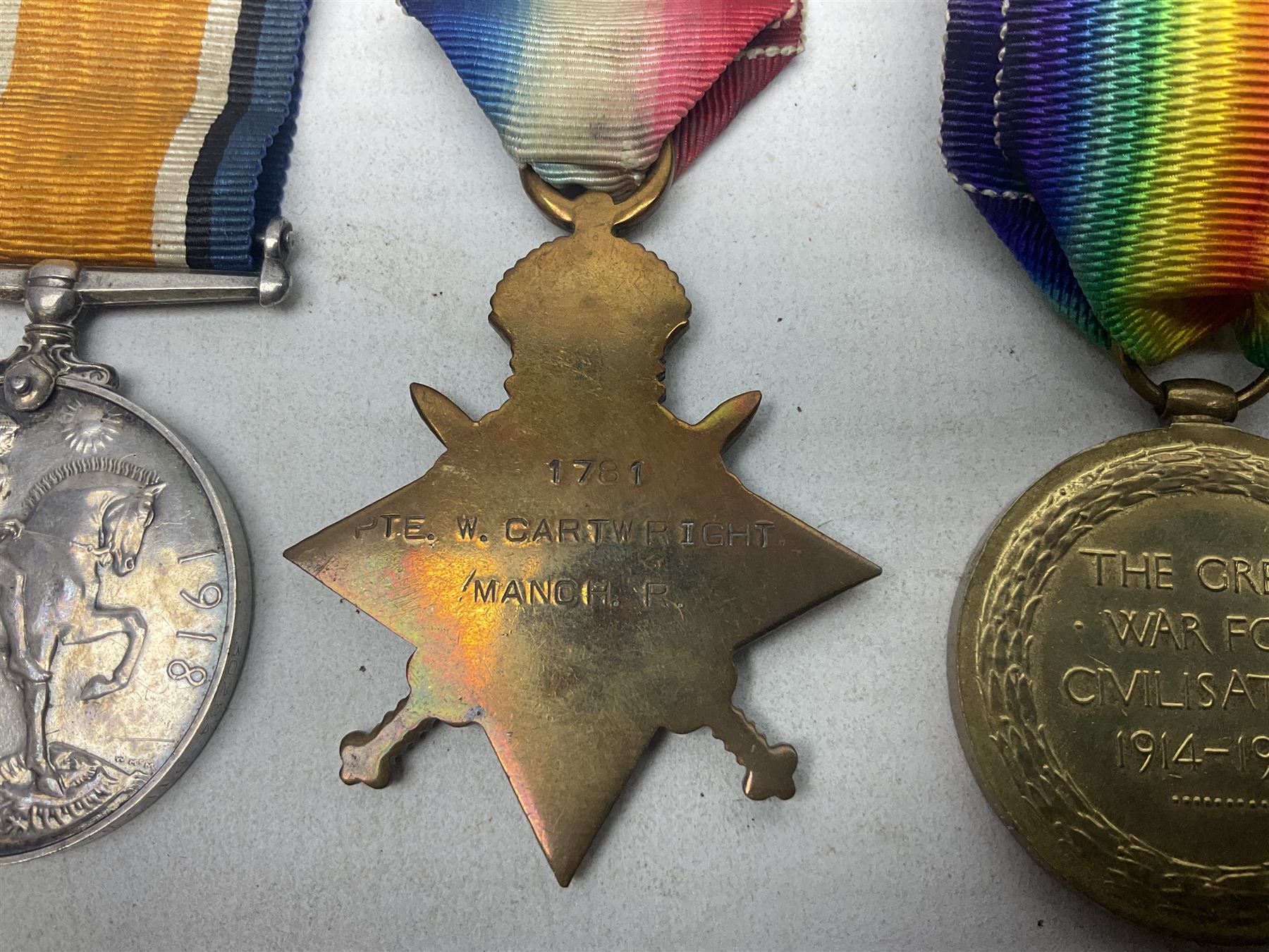 WW1 group of three medals comprising British War Medal, 1914-15 Star and Victory Medal awarded to 1781 Pte. W. Cartwright Manch. R.; and another WW1 British War Medal awarded to 30284 Pte. W.H. Paterson Manch. R.; all with ribbons (4)