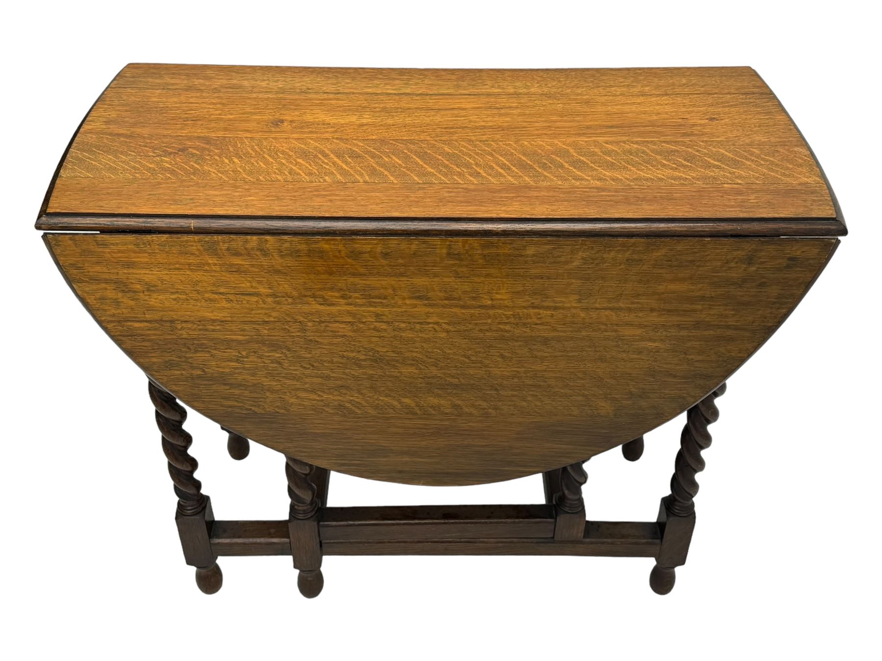 Early 20th century oak gateleg table, oval top with drop leaves supported by barley twist swing supports, united by plain stretchers, on turned feet (W119cm, D92cm, H77cm);