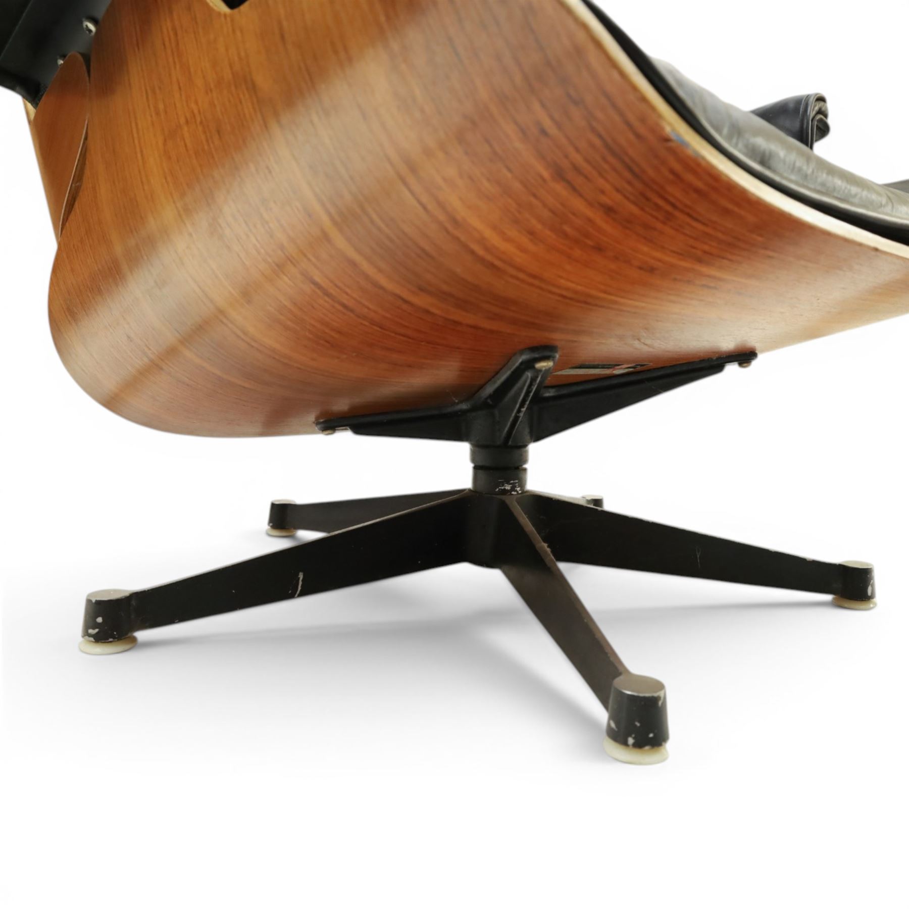 Charles and Ray Eames for Herman Miller - lounge chair, moulded veneered plywood shell with buttoned black leather upholstery, separate headrest and back cushions, padded armrests, on black cast aluminium five-star swivel base, manufactured under licence by Hille of London