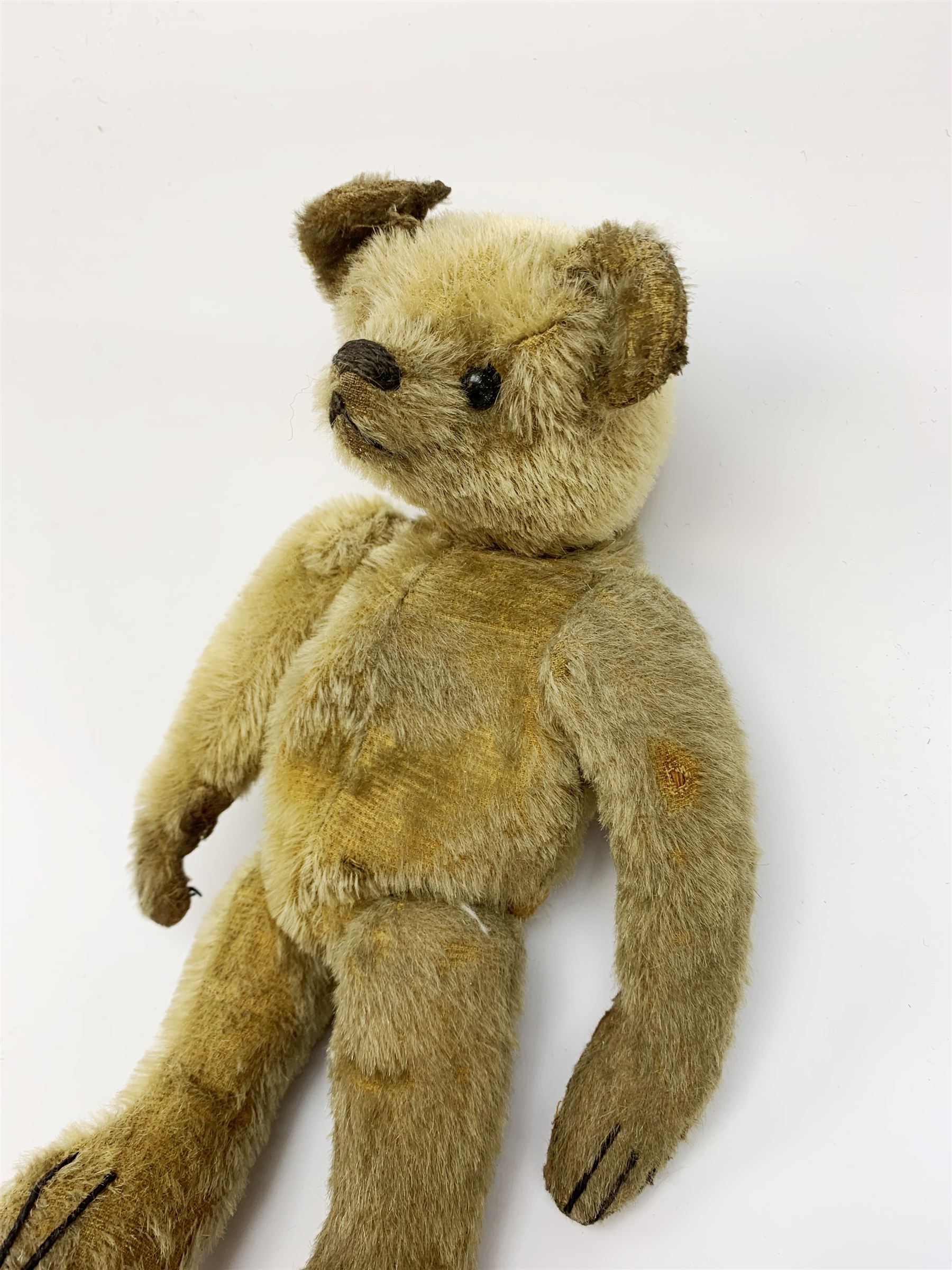 Early 20th century American mohair teddy bear c1920 with wood wool filled body humped back body with jointed limbs, black boot button eyes and horizontal stitched nose and mouth H12