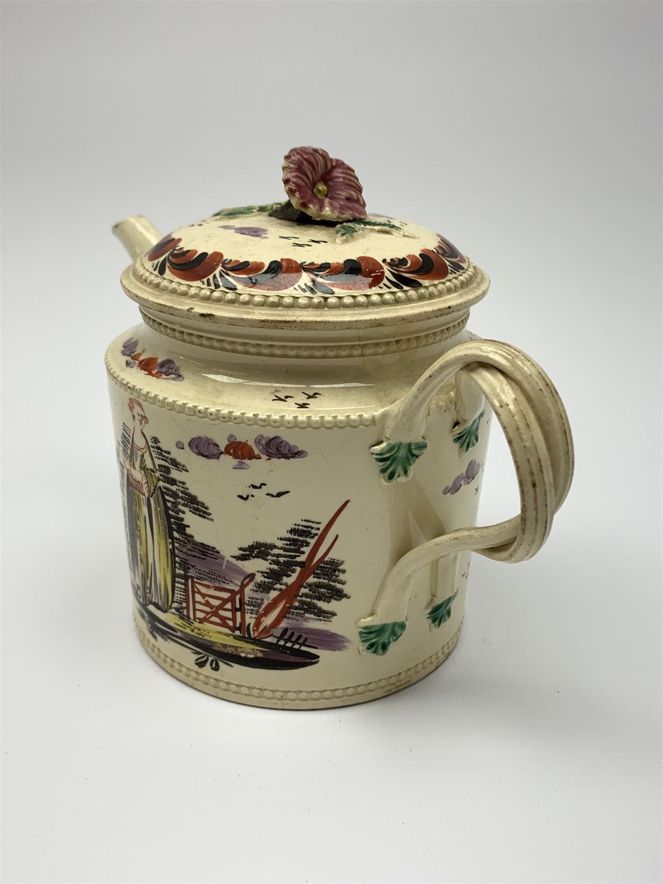 18th century creamware teapot, probably Leeds, with reeded entwined handle and floral finial to the cover, the body with hand painted polychrome decoration of figure to one side, and floral spray to the other, collectors paper label beneath inscribed Leeds Pottery, H11.5cm