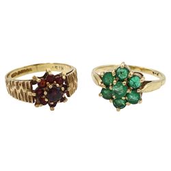 Gold garnet cluster ring with bark effect shoulders and a gold emerald flower head cluster ring, both stamped or hallmarked 9ct 