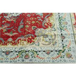 Persian silk inlaid crimson ground Kashan rug, the central shaped field with a floral pole medallion surrounded by trailing floral motifs and festoons of flowerheads, the wide cyan guard line with repeating palmettes and scrolling floral vines