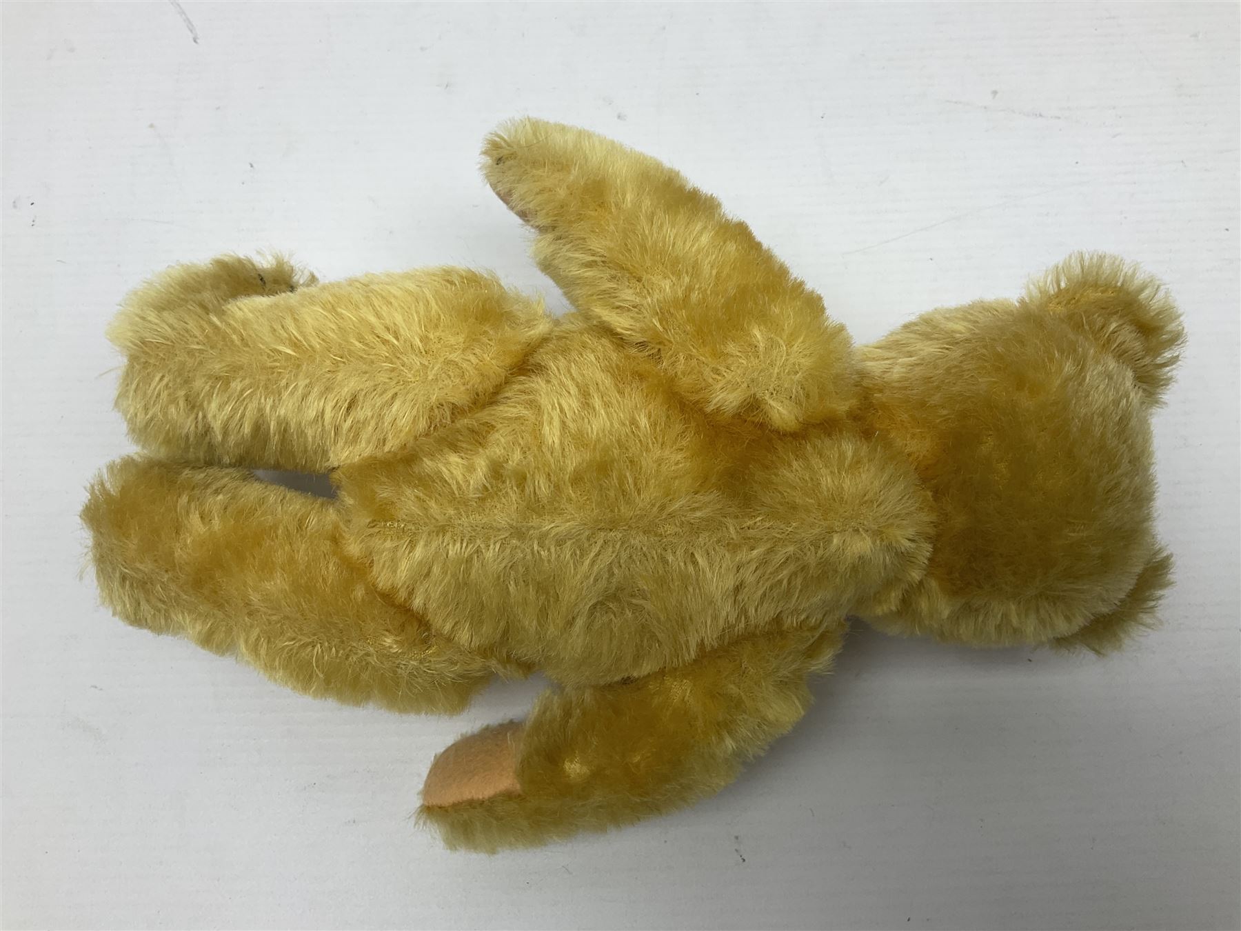 Steiff teddy bear with golden plush body, revolving head, applied eyes, vertically stitched nose and mouth and jointed limbs; button to left ear H26cm; and two other Steiff teddy bears, each with open mouth and button with tag to left ear (3)
