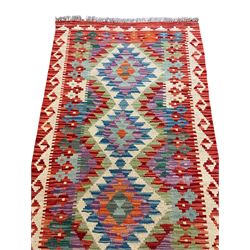 Chobi Kilim red ground and multi-coloured runner, decorated with overall geometric design, trailing lozenges within hooked border