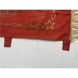 1970s Soviet banner printed in gold on a red ground, roughly translates as 'Transferable Banner - To the winner in the Socialist Competition' and 'Work Study Live by Communism' verso; wreath of wheat ears to either side; tassels on three sides 110 x 155cm