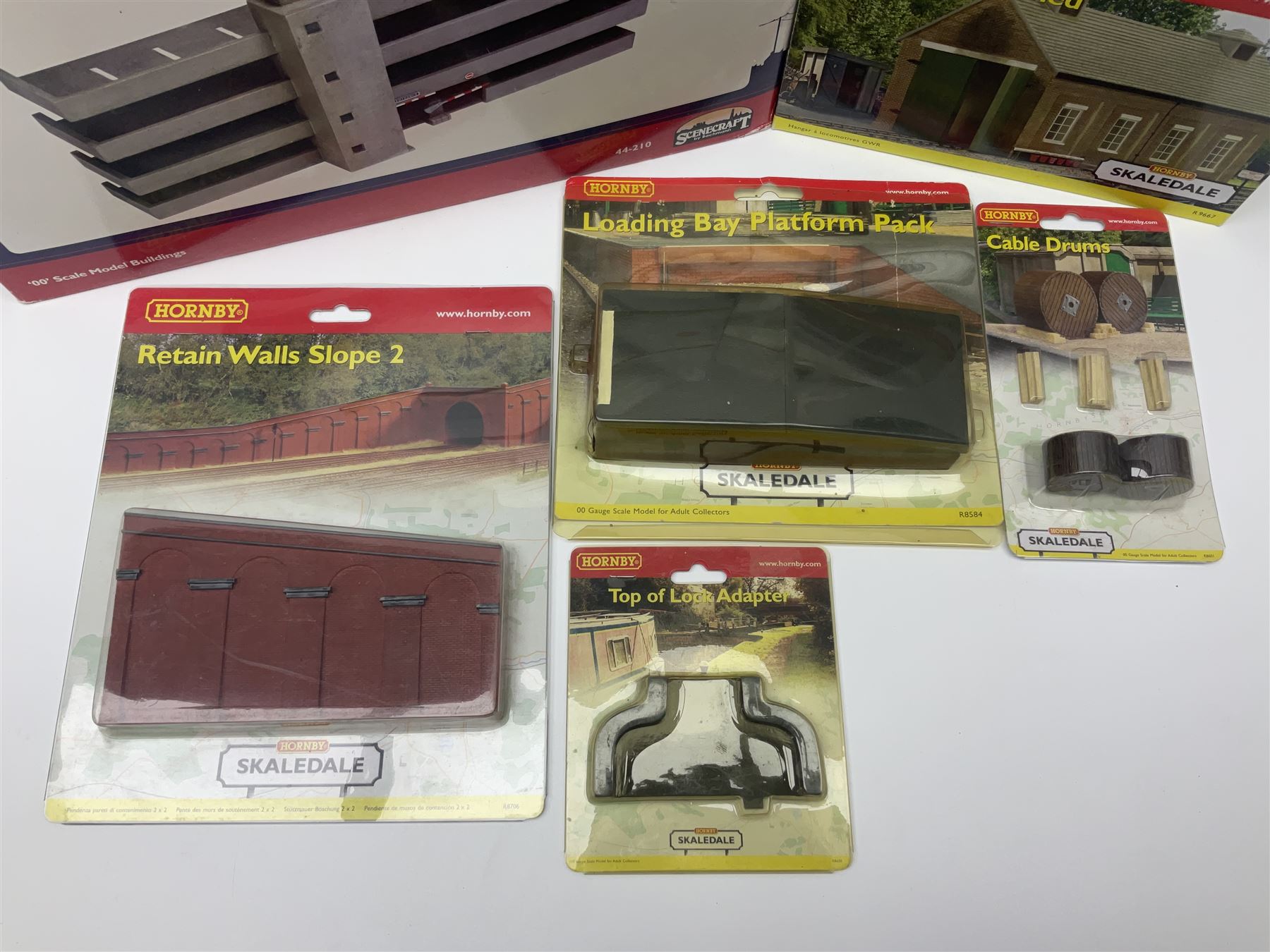 Hornby '00' gauge Skaledale/Bachmann Scenecraft - ten trackside buildings/accessories including 44-210 Low Relief Multi-Storey Car Park, R8737 Small Gasholder, R9667 GWR Engine Shed, R9674 Dent Snow Huts, R9709 'Headingly' Insurance Office, R8569 Canal bridge, R8584 Loading Bay Platform Pack, R8706 Retain Walls Slope 2 etc; all boxed (10)