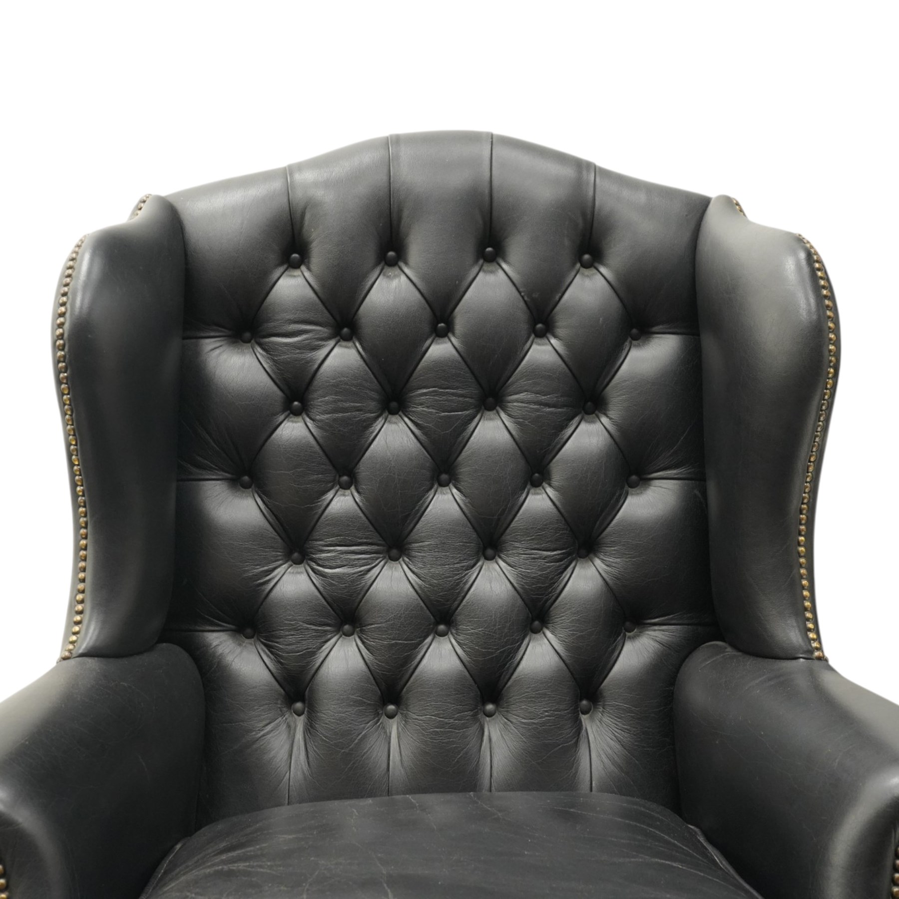 Pair of quality Georgian design wingback club armchairs, the high arched back with wings over rolled arms, upholstered in back-buttoned black leather with loose seat cushion, raised on foliate carved cabriole supports