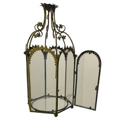 19th century brass and clear glass hexagonal hall lantern, with scrolling wire work open domed top over six arched panels, including a hinged door, the base enclosed with a circular glass panel on turned feet, H64cm