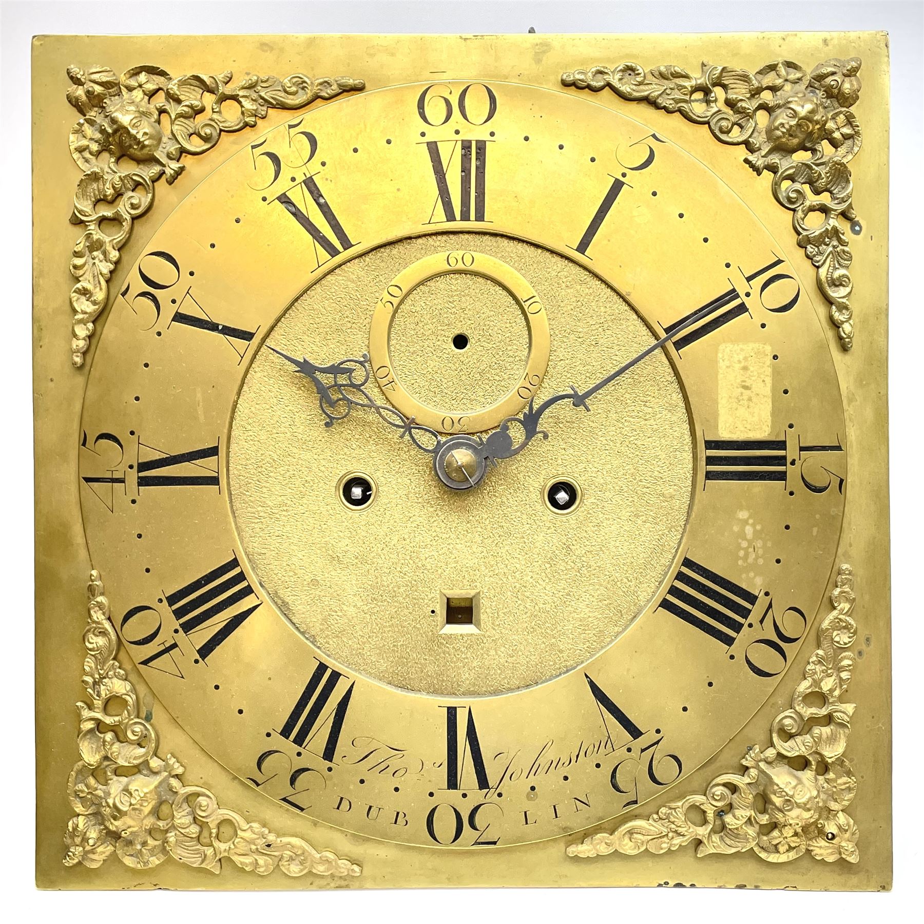 Late 18th century clock movement and dial, square brass dial with Arabic and Roman chapter ring signed 'Thos. (Thomas) Johnston, Dublin', with subsidiary seconds dial and calendar aperture, the dial set with ornate mask cast spandrels, twin train eight day movement striking on bell, with anchor escapement (34.5cm x 34.5cm, 13 1/2