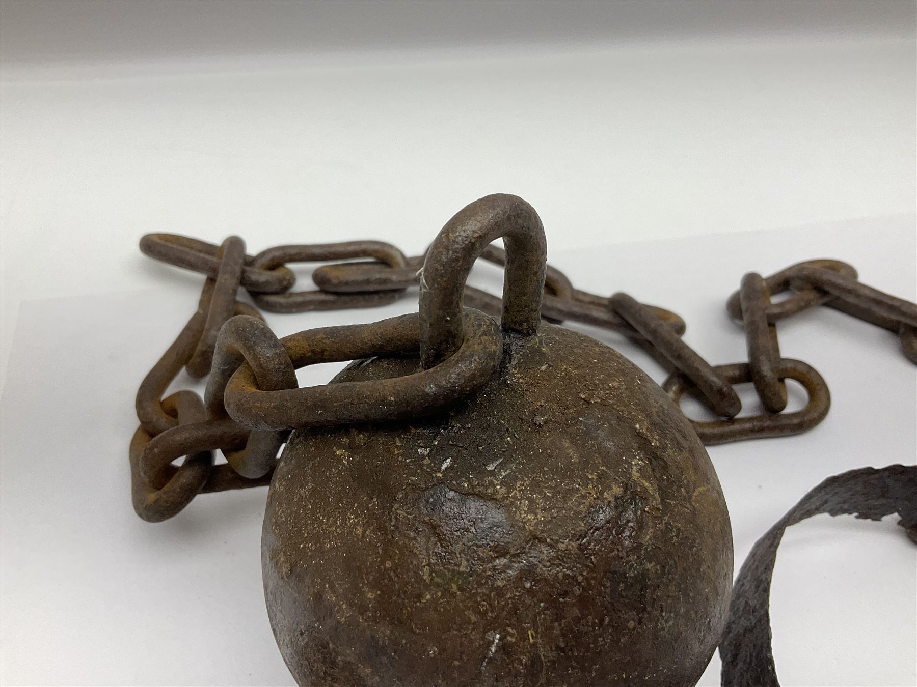 Late 19th/early 20th century prisoners iron ball and chain, with leg manacle; small cannon ball and grape shot