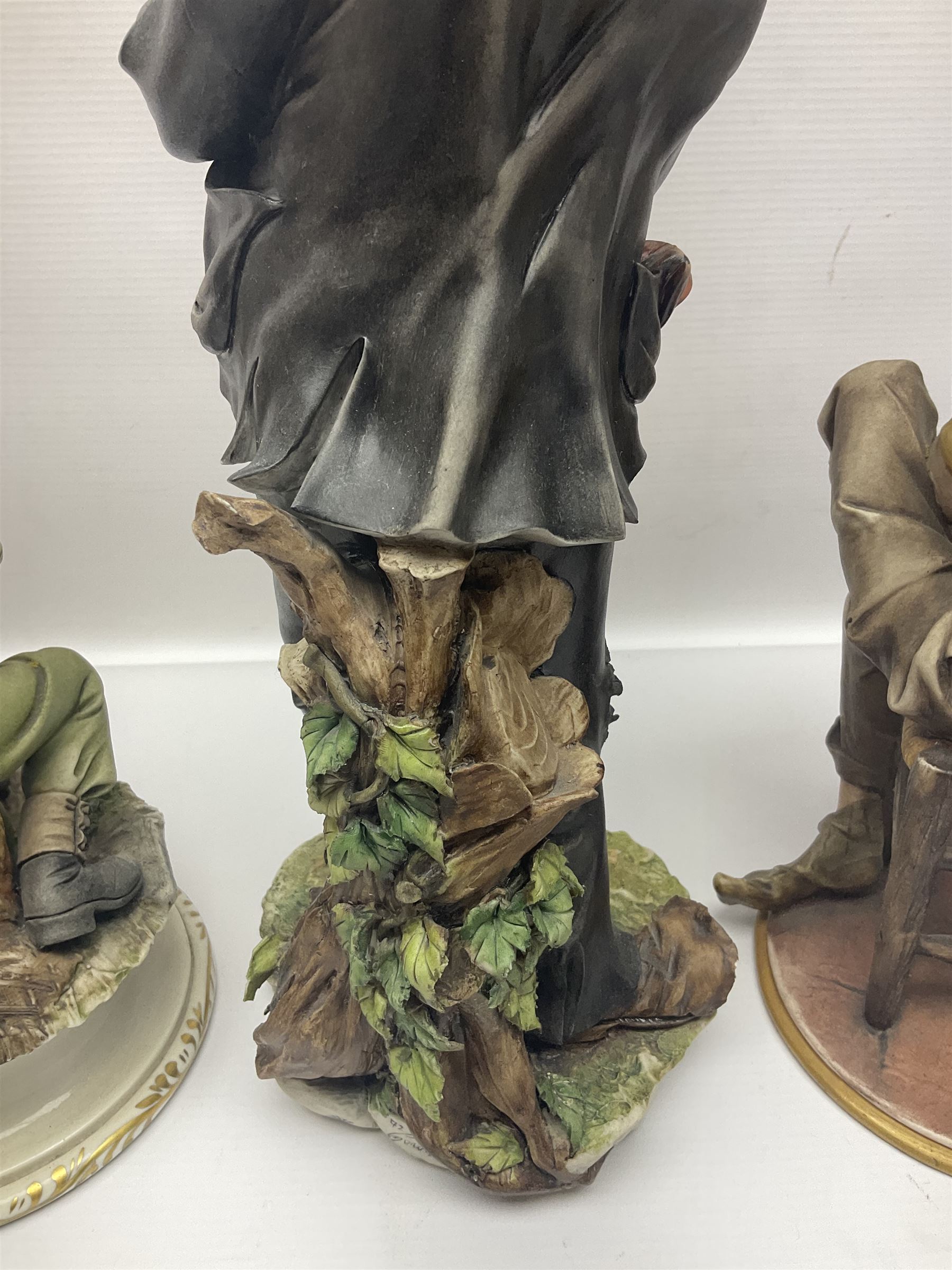 Three Capodimonte figures, to include The Kind Heart Man, modelled by Cortese as a tramp with two doves, The Young Falconer by Maria Angela and another modelled as a tramp darning his socks, all with printed marks, tallest H39cm