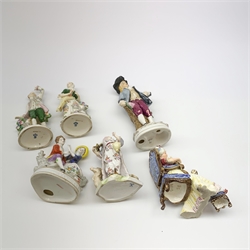 A pair of Sitzendorf figures, modelled as a male and female figure in eighteenth century dress with sheep beside feet, each upon gilt detailed circular base, each with printed mark beneath, tallest H18.5cm, together with a Volkstedt figure modelled as a Eastern female figure with camel seated at her feet, with printed mark beneath, a Sitzendorf figure of a young male figure, a figure modelled as a seated female playing the lute, with dog seated upon her lap, and a figure group marked foreign. (6). 