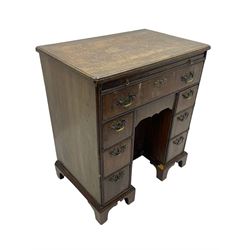 Georgian walnut kneehole desk, moulded rectangular top with book-matched veneers within crossbanding, fitted with slide over one long drawer, frieze drawer, six small drawers and recessed cupboard, raised on bracket feet