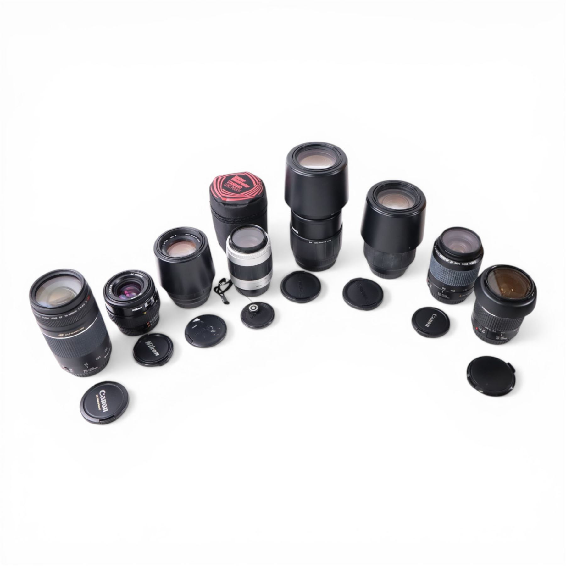 Eight camera lenses, comprising Canon Ultrasonic Zoom EF 75-300mm 1:4-5.6 lens, AF Nikkor 35-70mm 1:3.3-4.5 lens, Nikkor 60-180mm 1:4.5-5.6 lens, Canon Zoom EF 28-80mm 1:3.5-5.6 lens, Canon Zoom EF 80-200mm 1:4.5-5.6 lens, Sigma 70-300mm 1:4.6-5.6 DL Macro, Sigma Zoom 70-210mm 1:4-5.6 UCII lens and a Sigma AF 70-300mm 1:4-5.6 APO Macro lens, all with lens caps