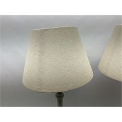 Pair of composite grey washed table lamps with a slender column upon a circular foot with natural linen shades