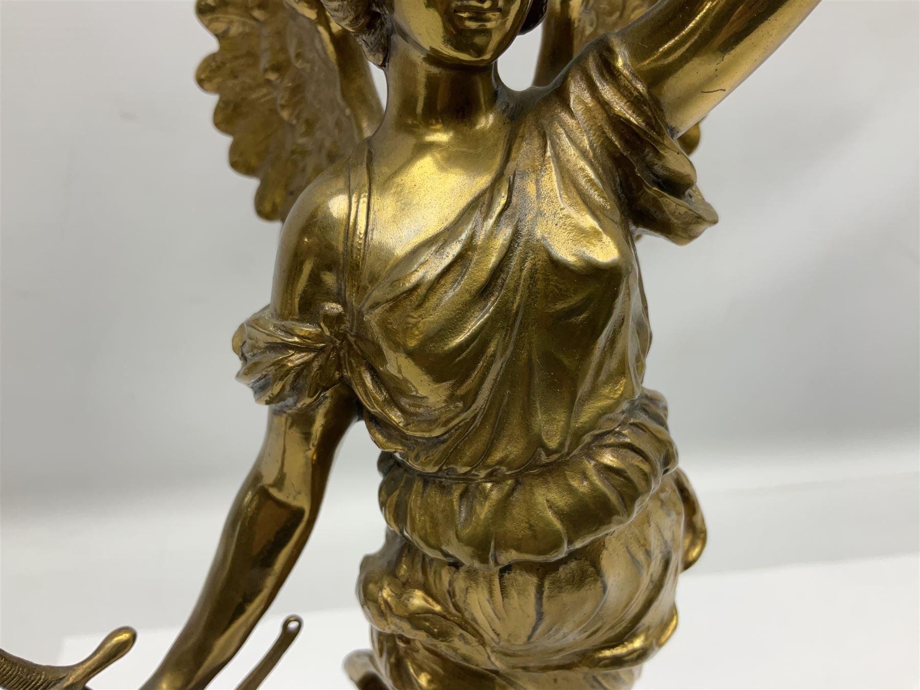 After Oswald Schimmelpfennig (German, 1872-1939): Pair of gilt bronze winged Allegorical female figures, the first example with arm outstretched holding a branch, signed 'Schimmelpfennig 1900', the second with arm raised above her head holding a book and sword in the other, both raised upon marble plinths, H45cm
