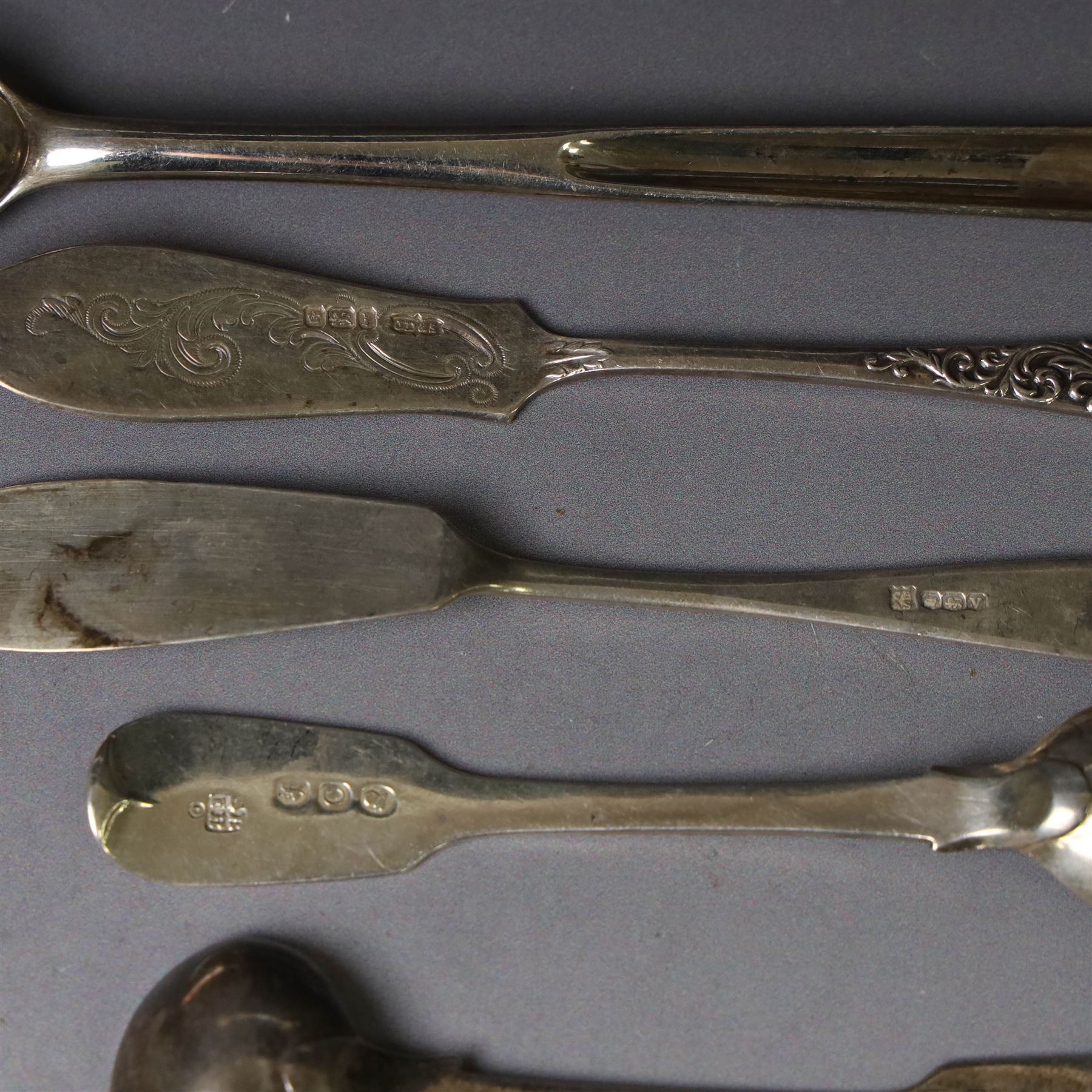 George III silver marrow scoop, hallmarked London 1767, makers mark indistinct, together with a collection of silver condiment spoons and butter knives, all hallmarked