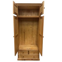 Solid pine double wardrobe, fitted with top box, enclosed by panelled doors, two short and one long drawer, on plinth base 