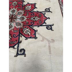 Persian Heriz rug, the ivory ground field with large floral central medallion and pale linear decoration, red ground guarded border with stylised floral and foliage motifs