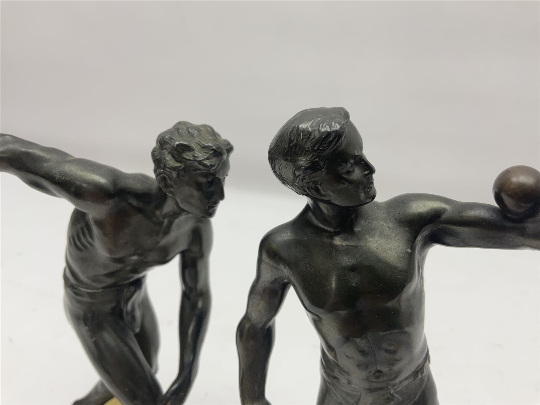 Bronzed model of the discus thrower and another of a episkyros player, both raised upon retangular plinths, H18cm