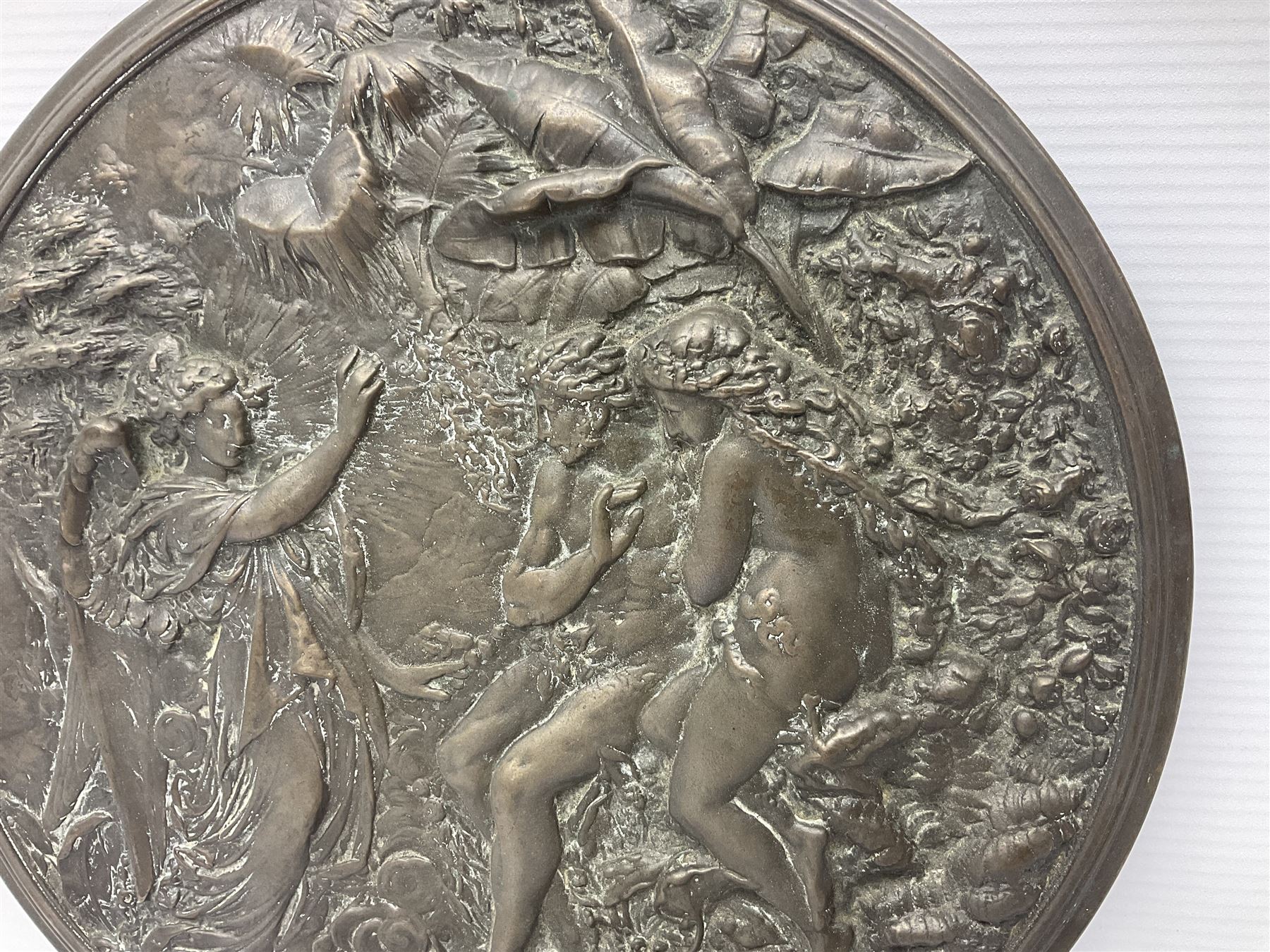 Late 19th century bronze plaque, of circular form, depicting the angel appearing to Adam and Eve in the garden of Eden in high relief, D25.5cm
