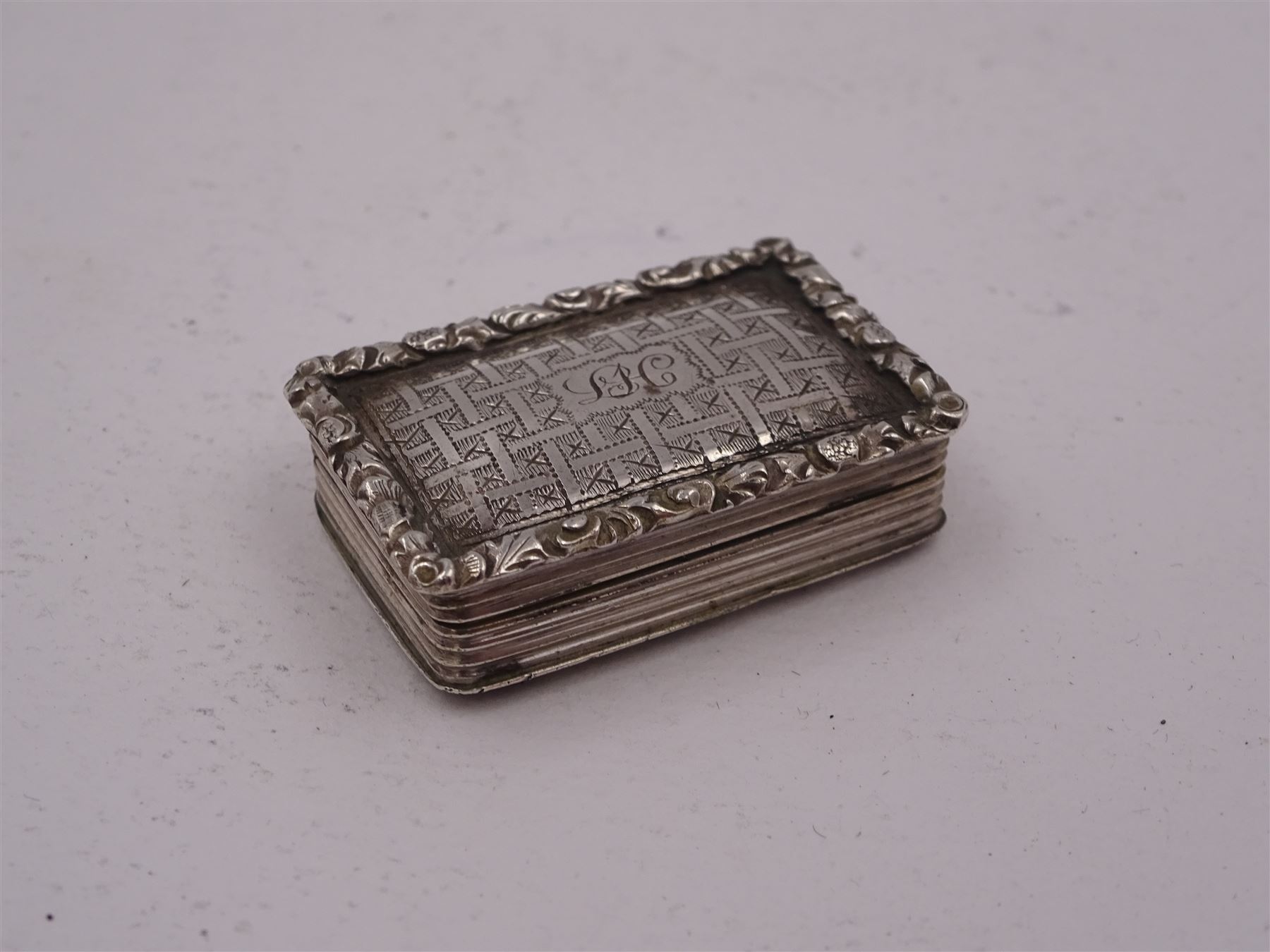 George III silver vinaigrette, of typical rectangular form, with raised foliate rim and engine turned decoration, with banded sides and foliate pierced engraving to gilt interior, hallmarked Birmingham 1797, maker's mark TS, L3cm