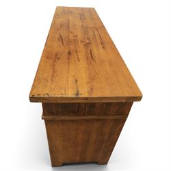 Indigo Furniture - large rustic oak sideboard fitted, with three drawers above three central drawers, flanked by fielded panelled doors, raised on bracket feet