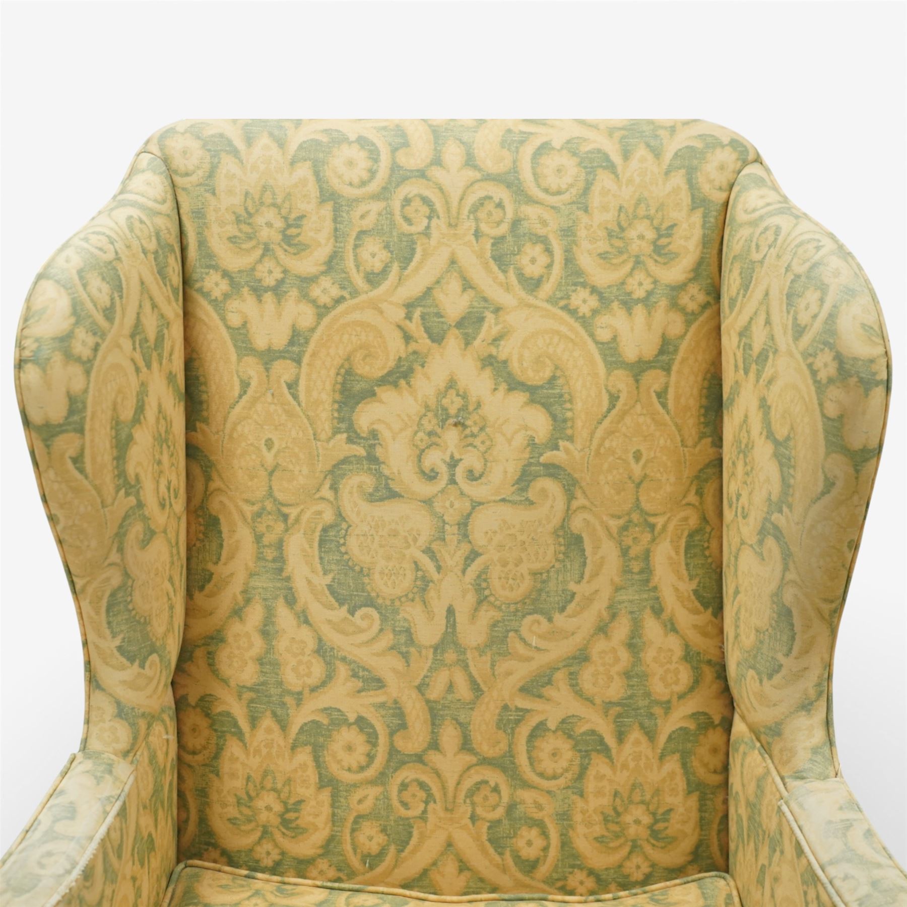 George III wing back armchair, the tall upholstered back with deep wings and gently shaped outline, padded arms flowing into the seat, loose cushion seat upholstered in a foliate patterned fabric, standing on square legs joined by stretchers