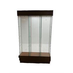 Light oak and glass triple display cabinet, glazed back and sides with three divisions, each with single glazed door enclosing three shelves, light fitting to top of each section