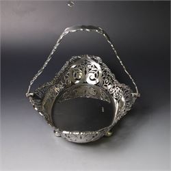 Early 20th century swing handled basket, of oval form with pierced sides and floral C scroll rim, upon four bun feet, hallmarked William Hutton & Sons Ltd, Sheffield 1915, widest point W29cm
