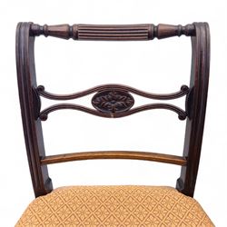Pair of Regency mahogany side chairs, reeded bar backs centred by oval paterae, overstuffed seats upholstered in gold geometric patterned fabric, on turned tapering front supports 
