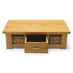 Contemporary pine coffee table, rectangular planked top with moulded edge, fitted with a central drawer to either side with brushed metal handle, flanked by two open compartments housing wicker basket drawers, plain sides, raised on square block feet