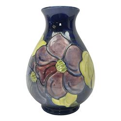 Moorcroft Clematis pattern vase of baluster form, upon a blue ground, with painted and impressed marks beneath, H22cm