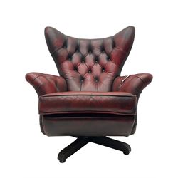 Mid-20th century Blofeld swivel and reclining armchair, triangular wingback over scrolled arms, upholstered in buttoned oxblood leather with studwork, on quadruform base
